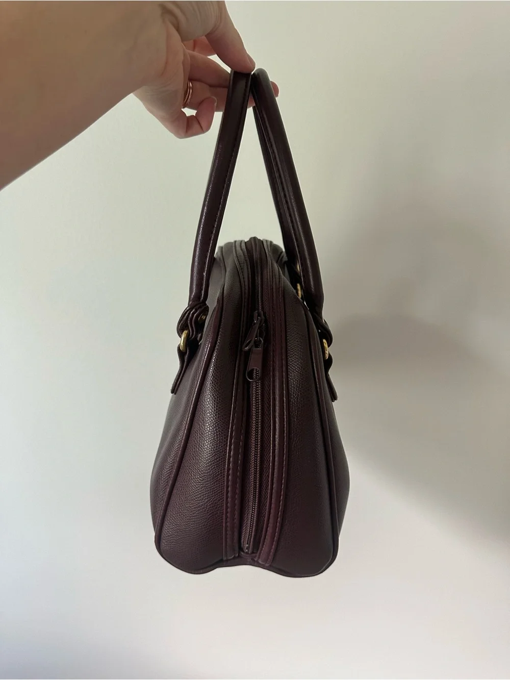 Vintage-inspired burgundy/oxblood structured handbag with gold accents
